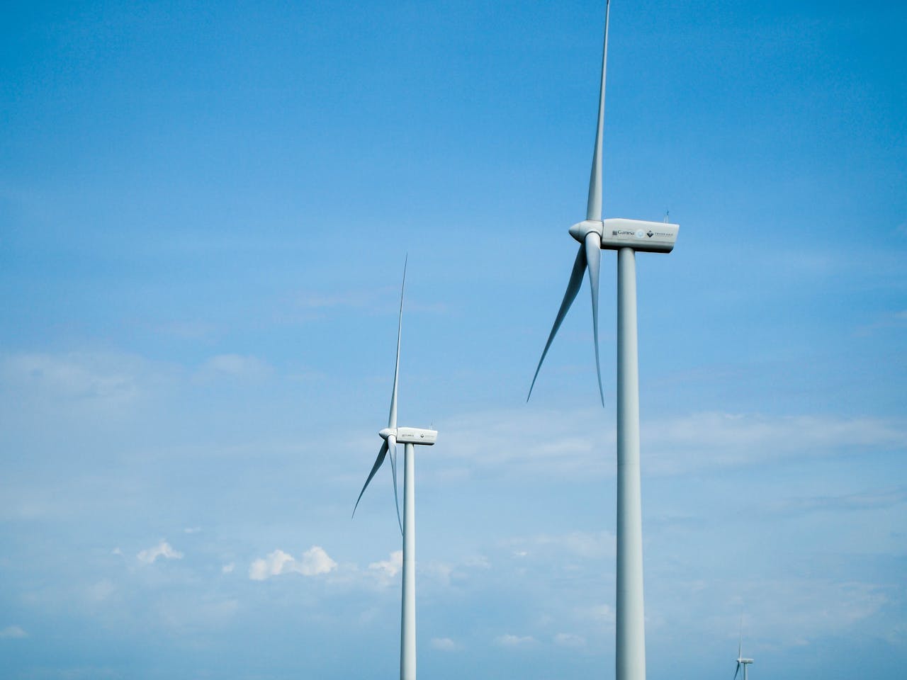 A scenic view of wind turbines in San Lorenzo, Western Visayas, with a clear blue sky.